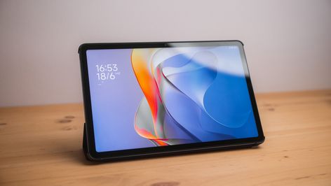 Tablet Redmi Pad 2 apoyada sobre una mesa de madera con la pantalla de bloqueo encendida.