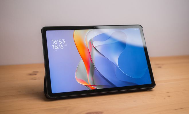 Tablet Redmi Pad 2 apoyada sobre una mesa de madera con la pantalla de bloqueo encendida.