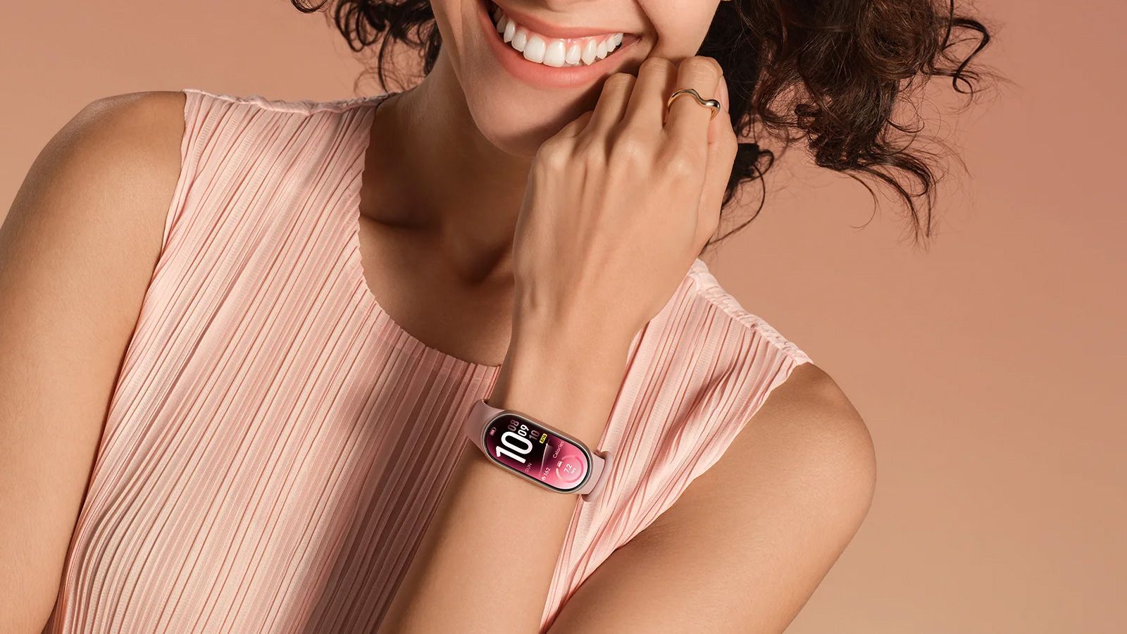 Primer plano de una persona llevando la Xiaomi Smart Band 11 con correa rosa y esfera digital en la muñeca.