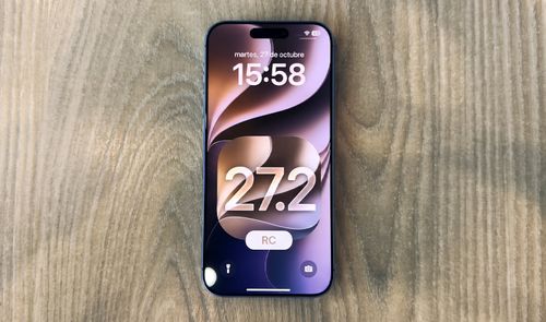 Vista frontal de un iPhone 18 Pro mostrando la pantalla de bloqueo con el número 27.2 sobre una superficie de madera.