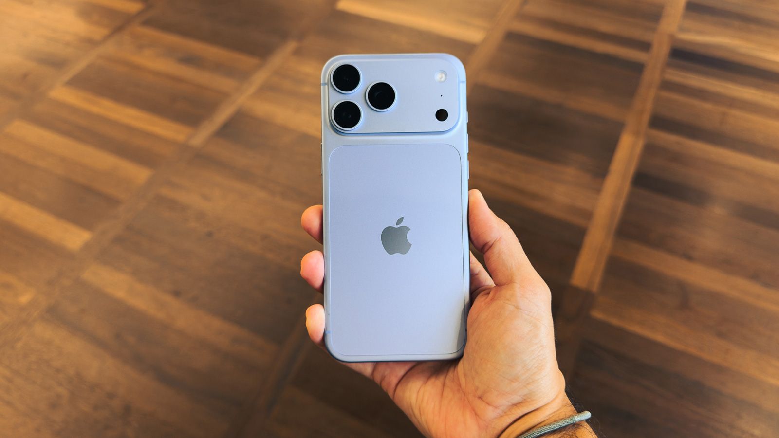 Parte trasera de un iPhone 18 Pro sostenido con la mano, mostrando un módulo de cámara rediseñado con tres lentes y sensores adicionales.