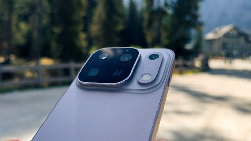 Primer plano del módulo de cámaras trasero de un teléfono inteligente OPPO Find X10 Pro Max en un entorno exterior desenfocado.