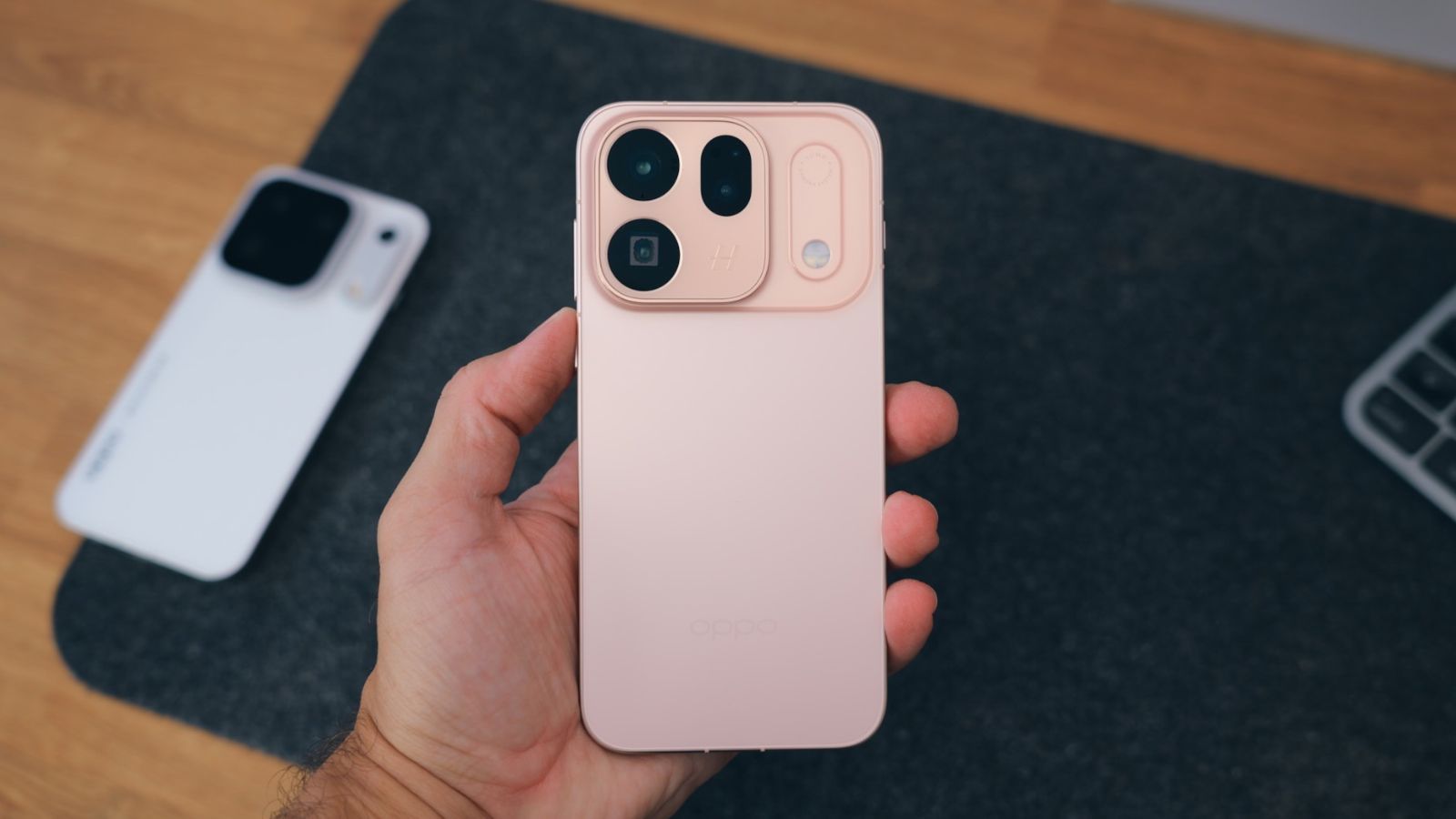 Mano sujetando el OPPO Find X10 en color rosa mostrando el diseño del módulo de cámaras y el flash alargado.
