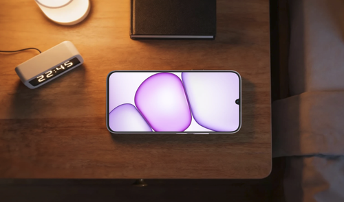 Teléfono móvil realme P4 Lite situado sobre una mesa de noche junto a un despertador digital y una lámpara.