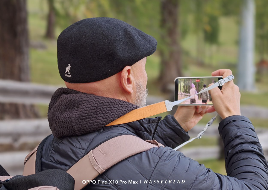 Hombre con gorra y mochila grabando un vídeo con el OPPO Find X10 Pro Max en un entorno natural.